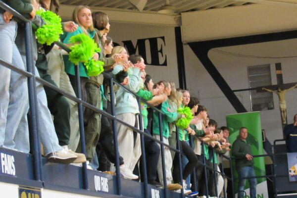 Quincy Notre Dame students dressed in green House shirts cheer on their team.