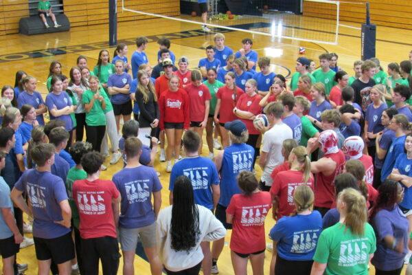 Quincy Notre Dame students gather in the gym to listen to volleyball referee before Raider Cup volleyball tournament.
