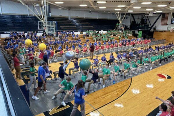 Quincy Notre Dame House activity in the gym with bog exercise balls being passed over students' heads.