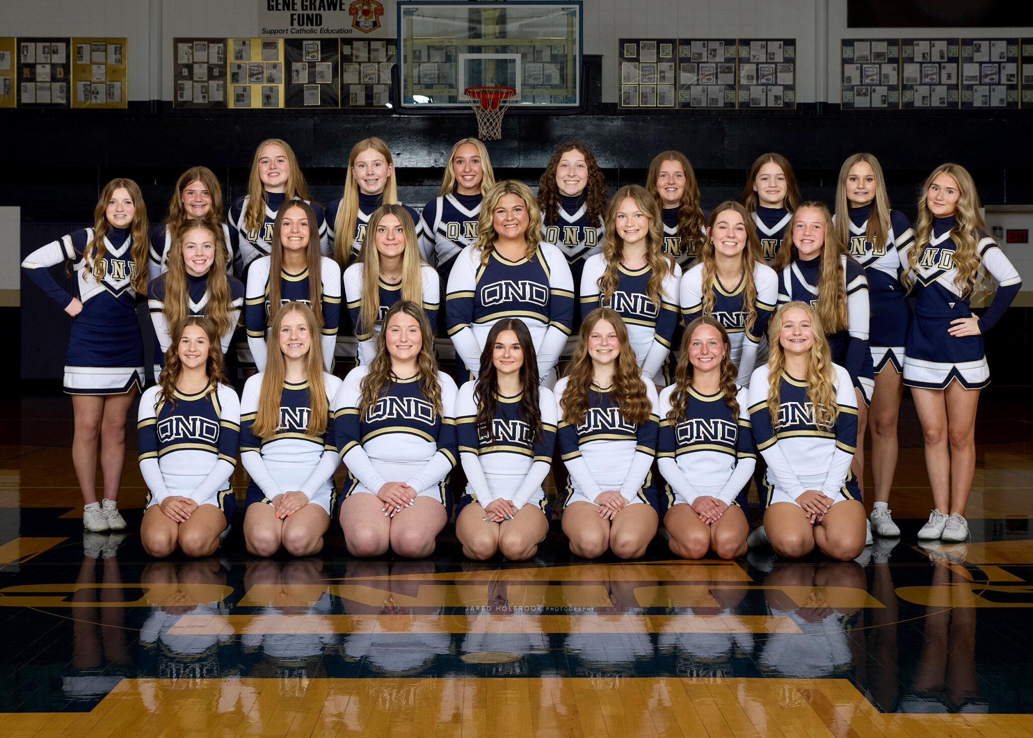 2025- 26 Cheerleading Picture Group of QND Cheerleaders pose for photo in the gym.