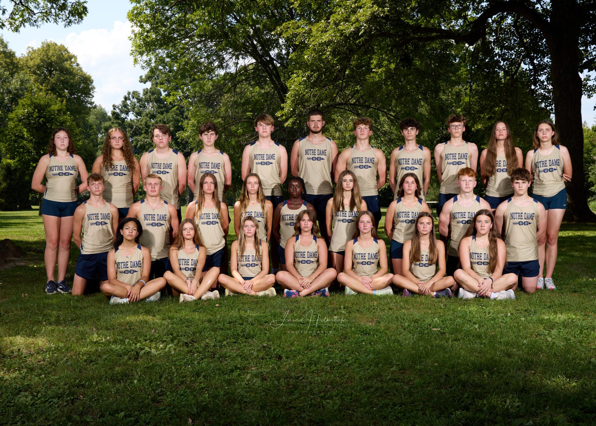 QND cross country team poses for photo outdoors.