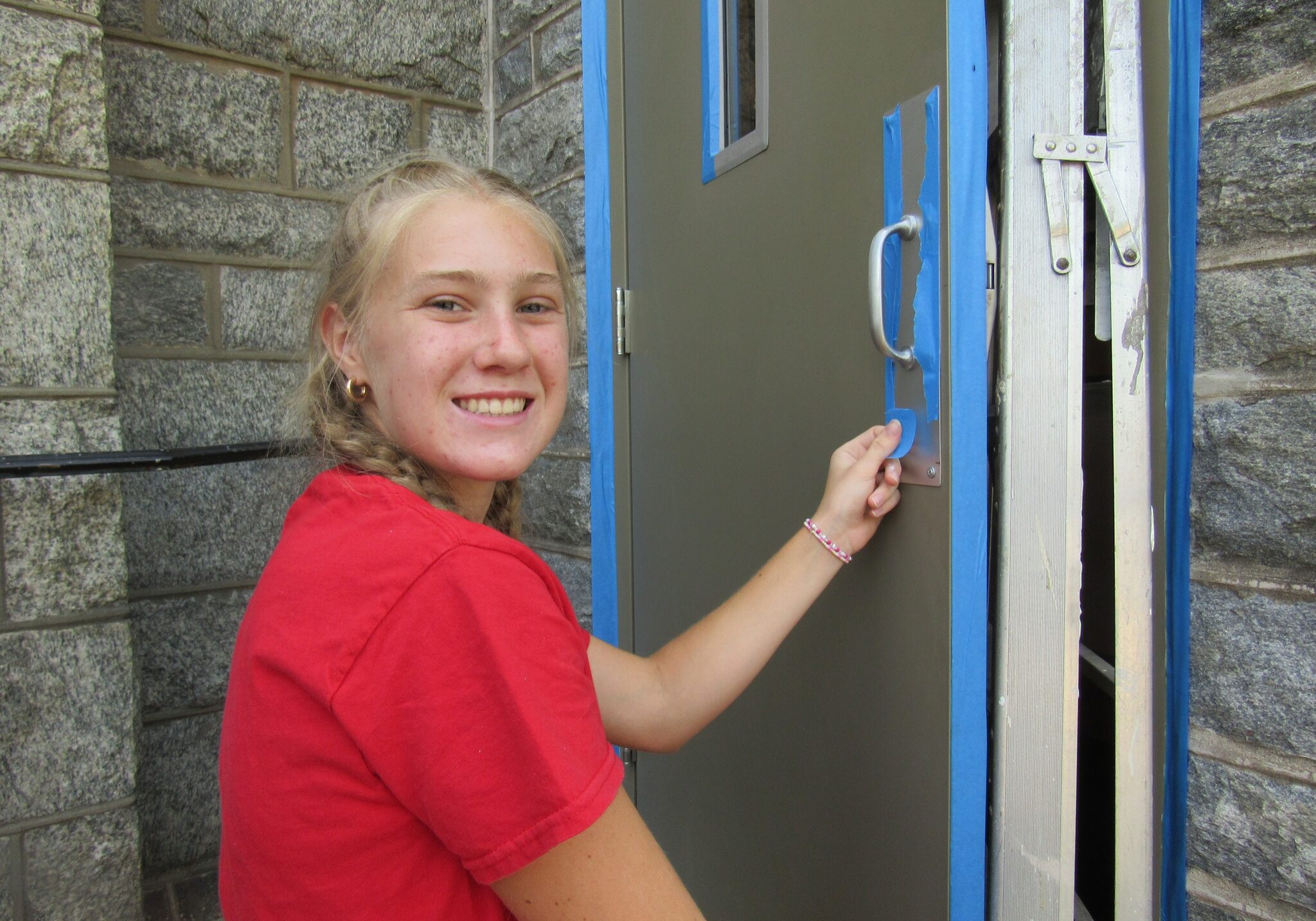 454029186_894680319363503_2297078122127820250_n Quincy Notre Dame High School female student painting a door.