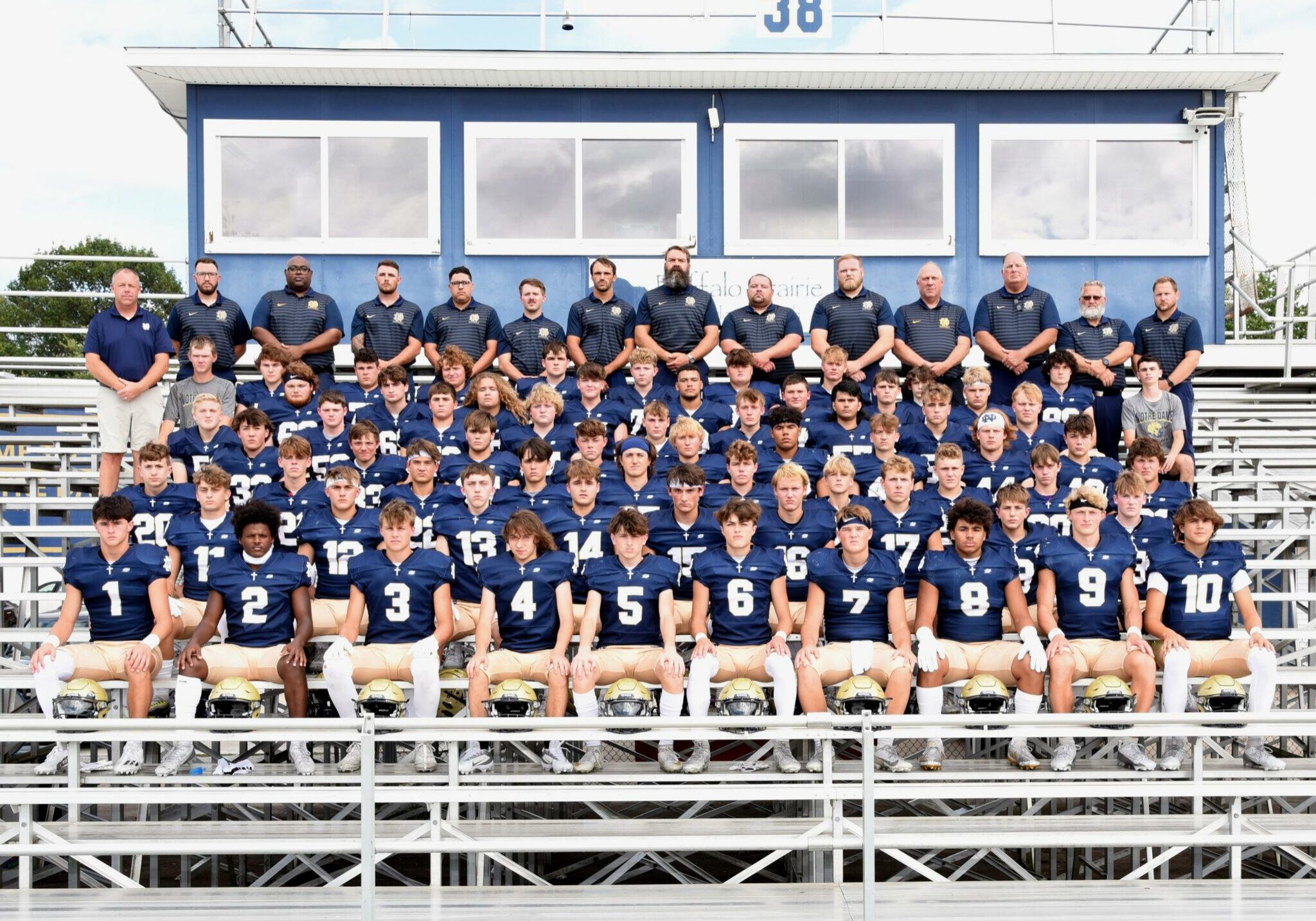 2024-25 Quincy Notre Dame varsity football team group photo on the field, players in uniform with coaches.