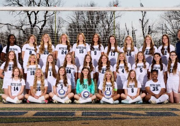 Quincy Notre Dame girls soccer team posing for a group photo on the field in uniform.