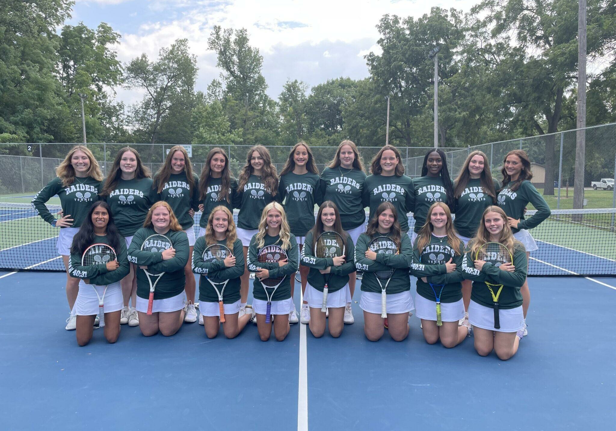 2024 Quincy Notre Dame girls tennis team group photo on the court with players in uniform holding rackets.
